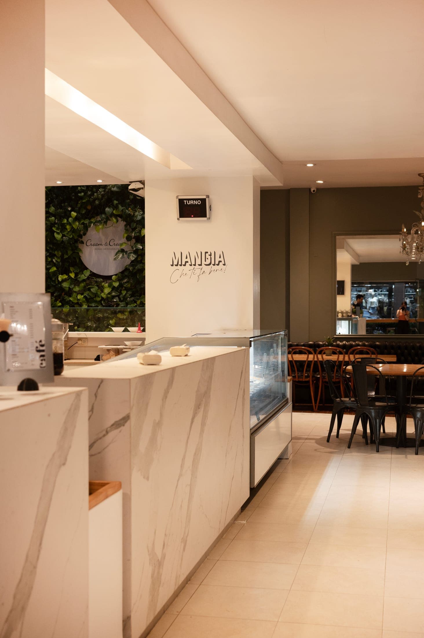 Mostrador de mármol del salón de Cream&Cream, con el mural verde de fondo